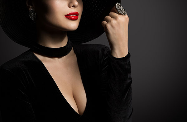 Young woman in a black dress and hat